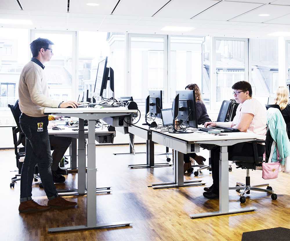 Employees at Cybercom working at Martela's electrically adjustable tables